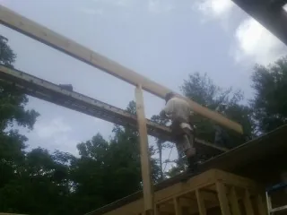 Carpenter setting a ridge beam over a new addition frame — Ice Dam Removal by Roofing Brothers in Beallsville