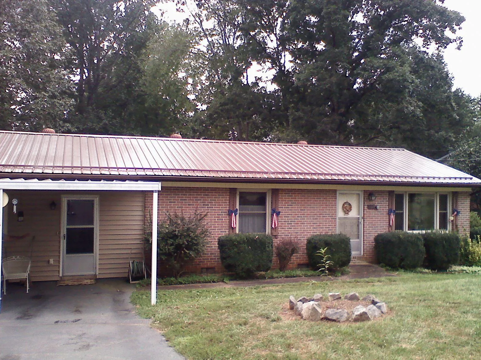 Bronze metal roof and carport on a brick ranch home — Roof Repair work by our crew in Beallsville